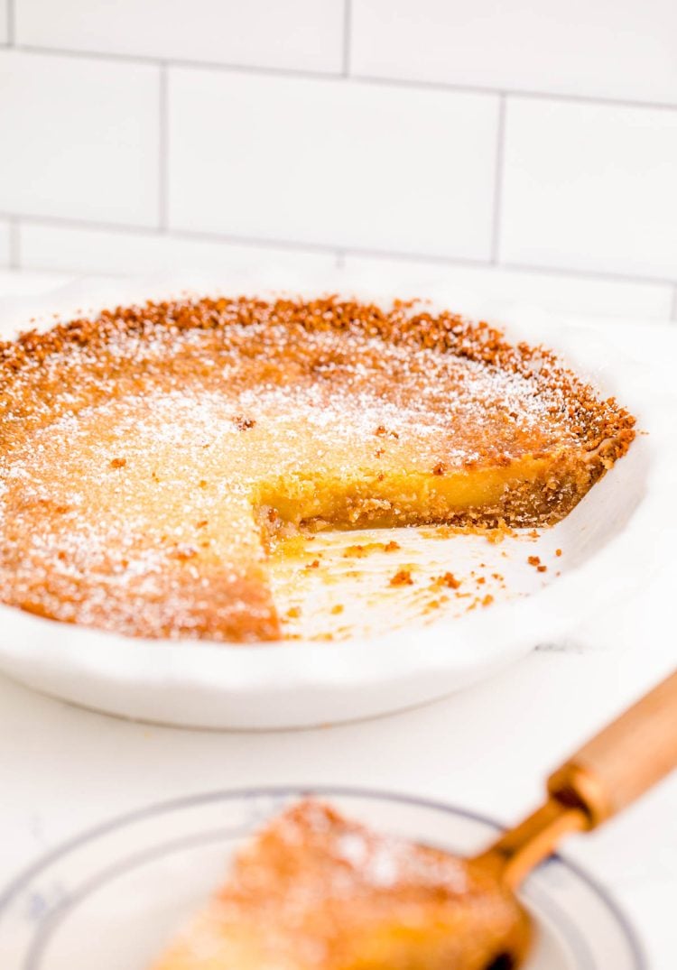 A Crack Pie on a white table with a slice missing.