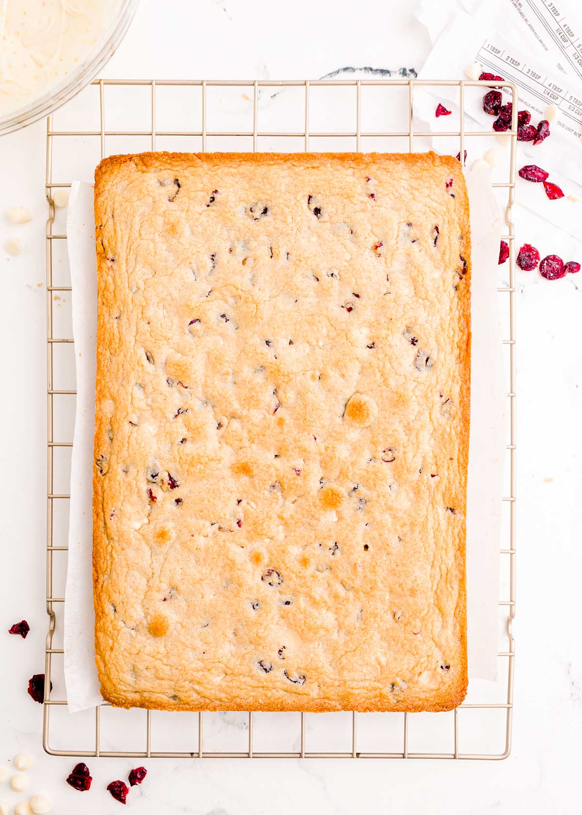 Baked cranberry bliss bars cooling on a wire rack.