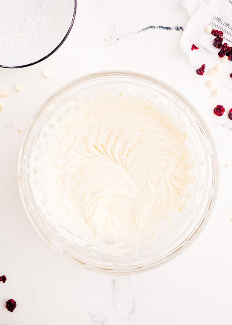Cream cheese frosting prepared in a glass bowl.