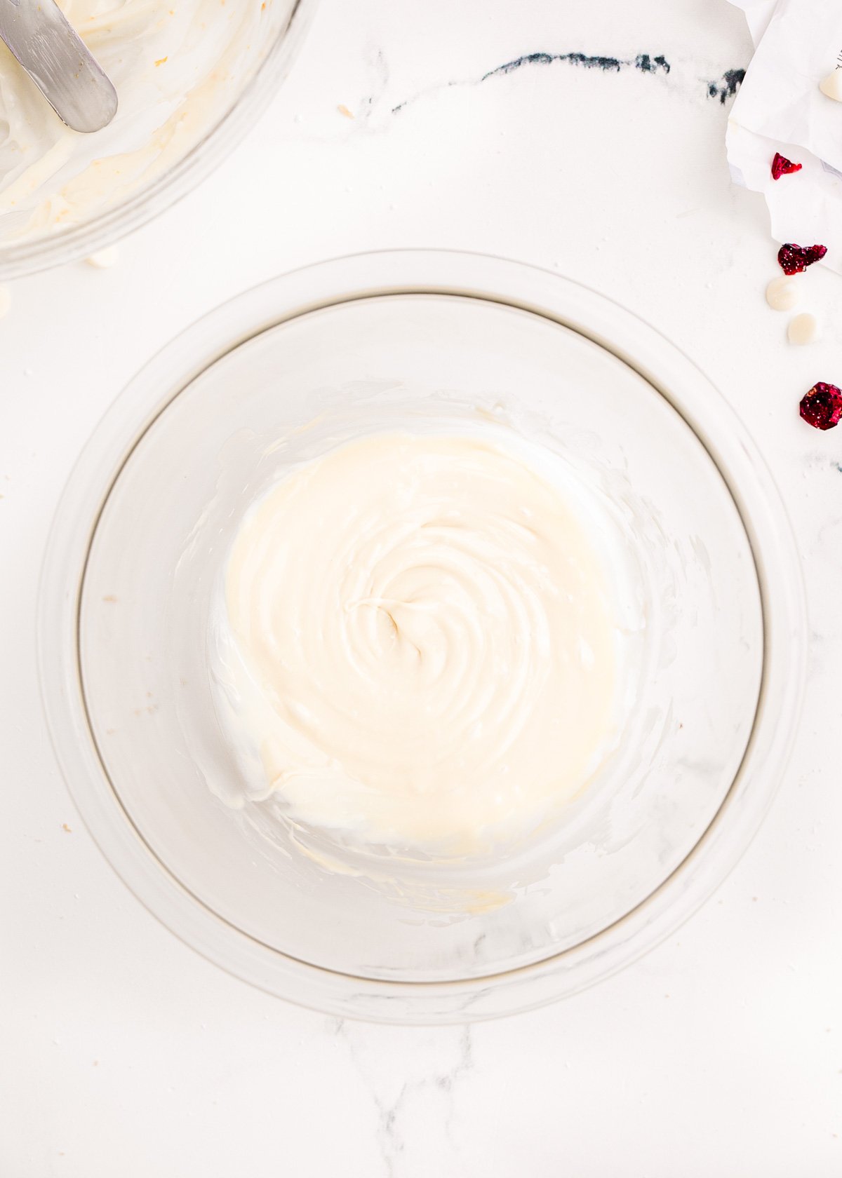 Melted white chocolate in a small glass bowl.