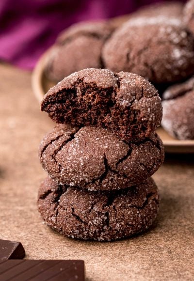 Close up photo of a stack of three chocolate sugar cookies with the top one missing a bite.