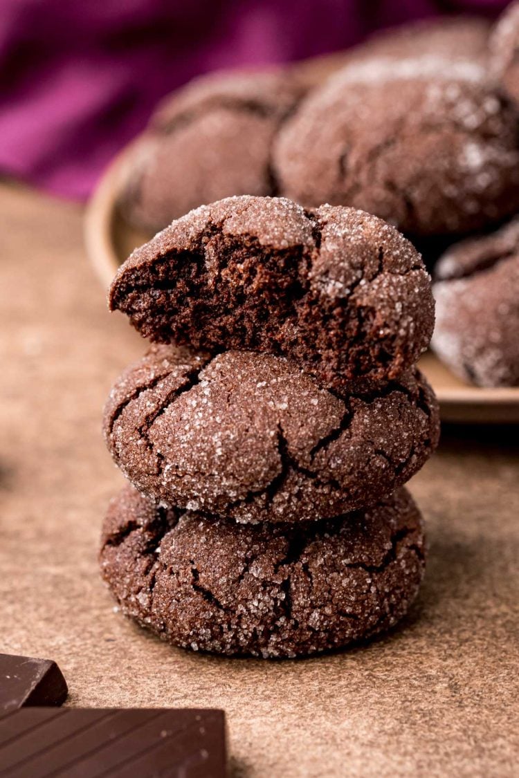 Close up photo of a stack of three chocolate sugar cookies with the top one missing a bite.