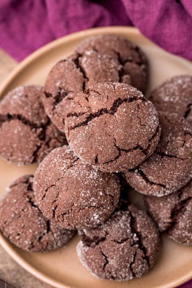 Soft chocolate sugar cookies on a brown plate on a purple napkin.