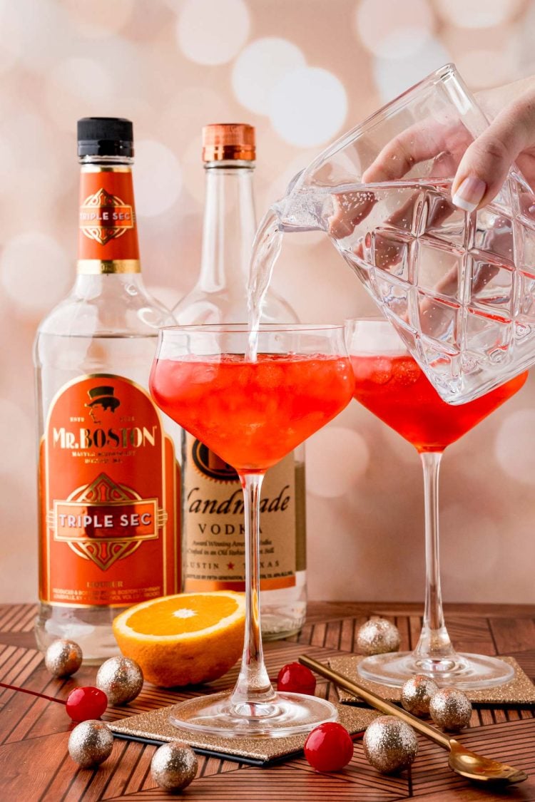 lemon-lime-soda being poured into a coupe glass to make a dirty shirley temple cocktail.