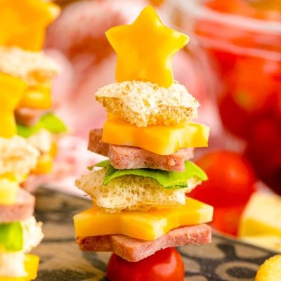 Close up photo of cute christmas appetizers made with bread and deli meat and cheese to look like christmas trees.