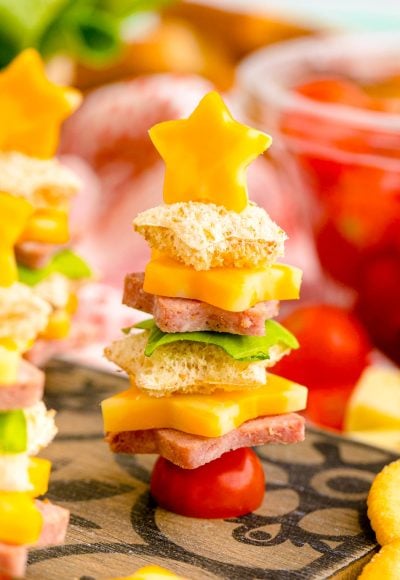 Close up photo of cute christmas appetizers made with bread and deli meat and cheese to look like christmas trees.