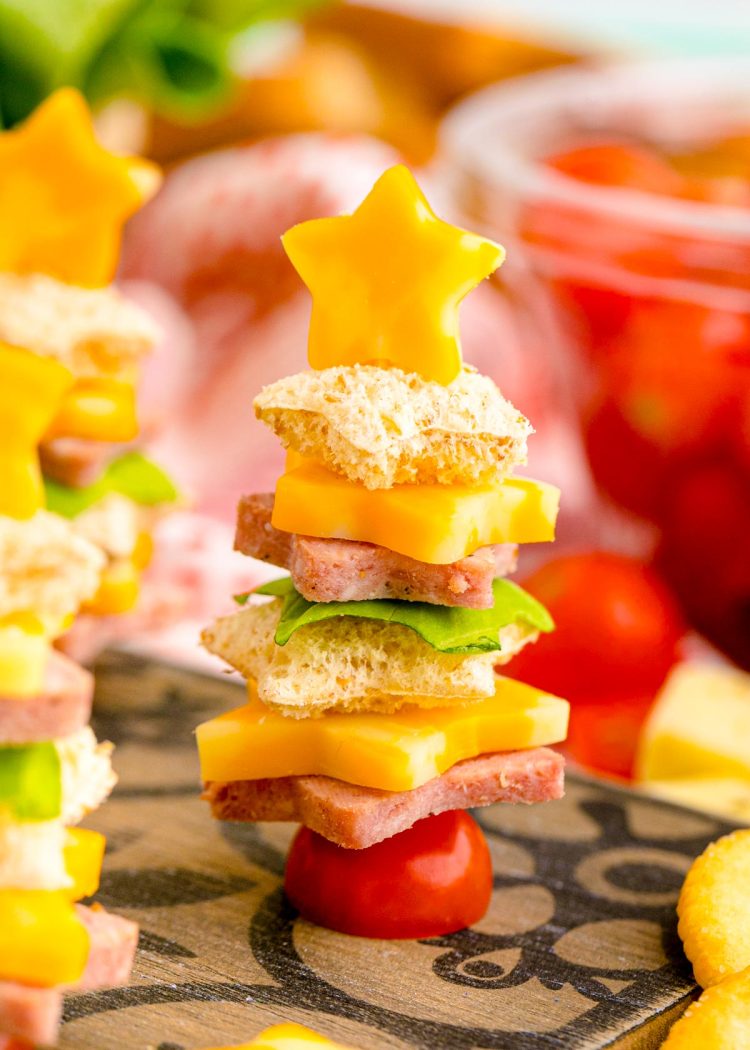 Close up photo of cute christmas appetizers made with bread and deli meat and cheese to look like christmas trees.