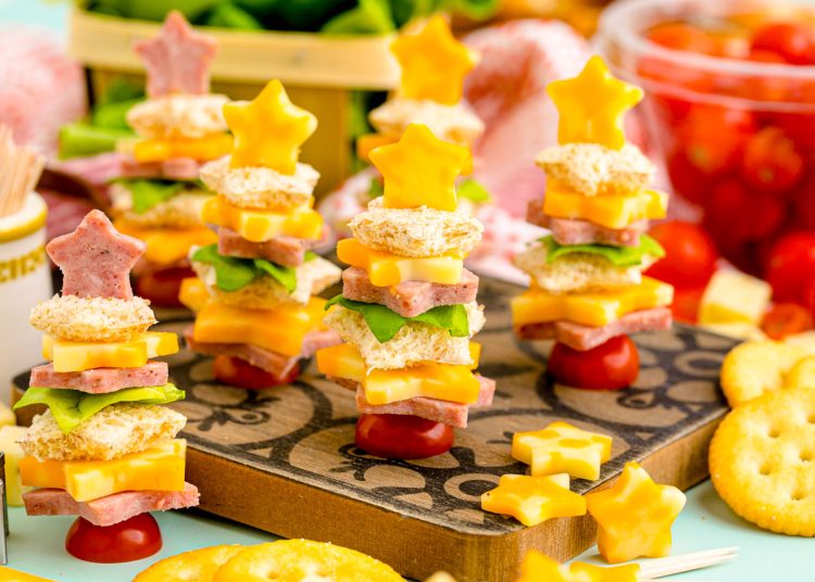 Easy Christmas tree shaped appetizers on a wooden cutting board ready to be served.