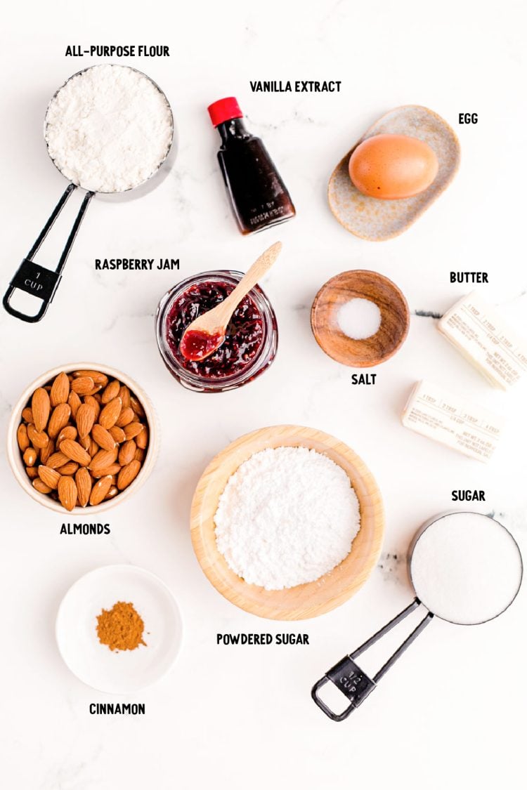 Overhead photo of ingredients to make linzer cookies on a white marble surface.