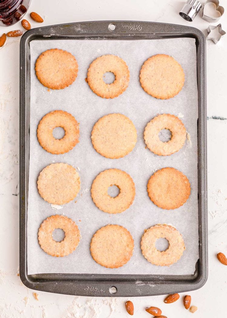 Linzer cookies on a parchment lined baking sheet.