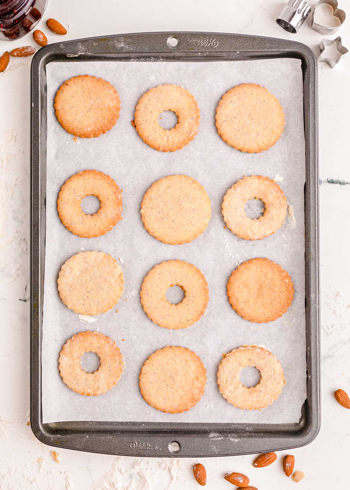 Linzer cookies on a parchment lined baking sheet.