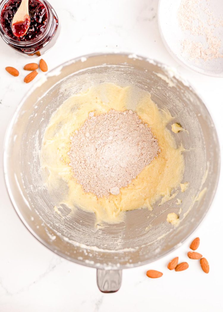 Overhead photo of flour mixture added to butter mixture in a stand mixing bowl.