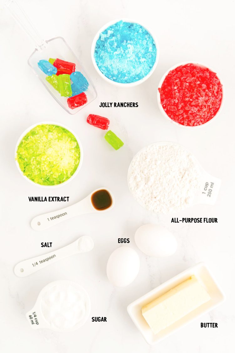 Ingredients to make stained glass cookies prepped on a marble surface. 