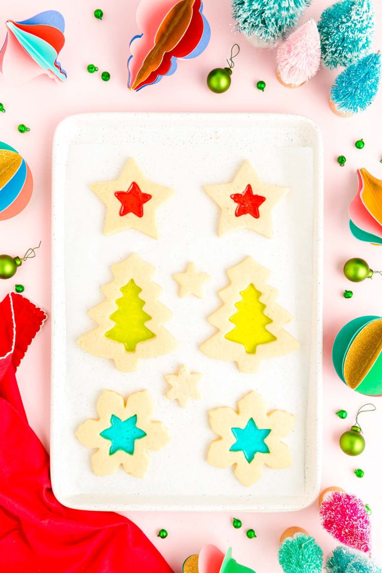 Stained glass cookies cooking on a baking sheet.