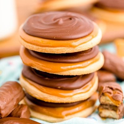 Close up photo of a stack of 4 twix cookies on a light blue napkin.