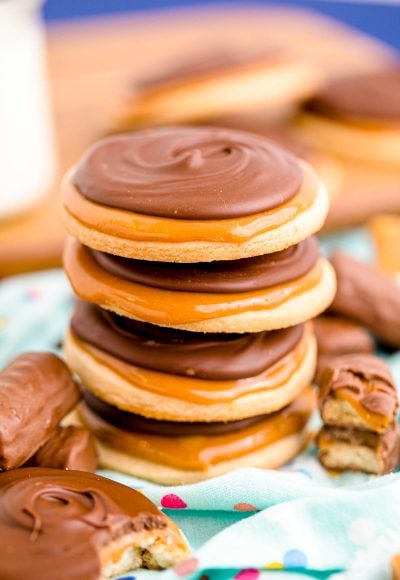 Close up photo of a stack of 4 twix cookies on a light blue napkin.