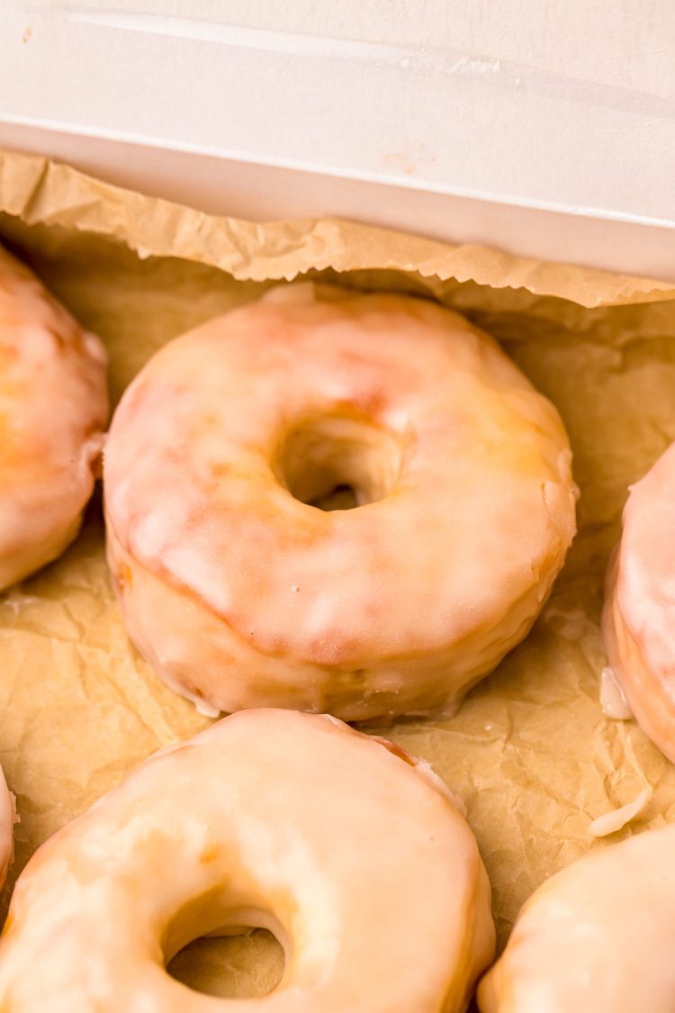 Glazed donuts on parchment paper.