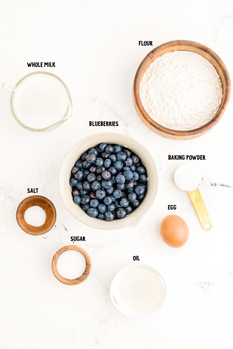 Overhead photo of ingredients prepped to make blueberry pancakes on a marble counter.