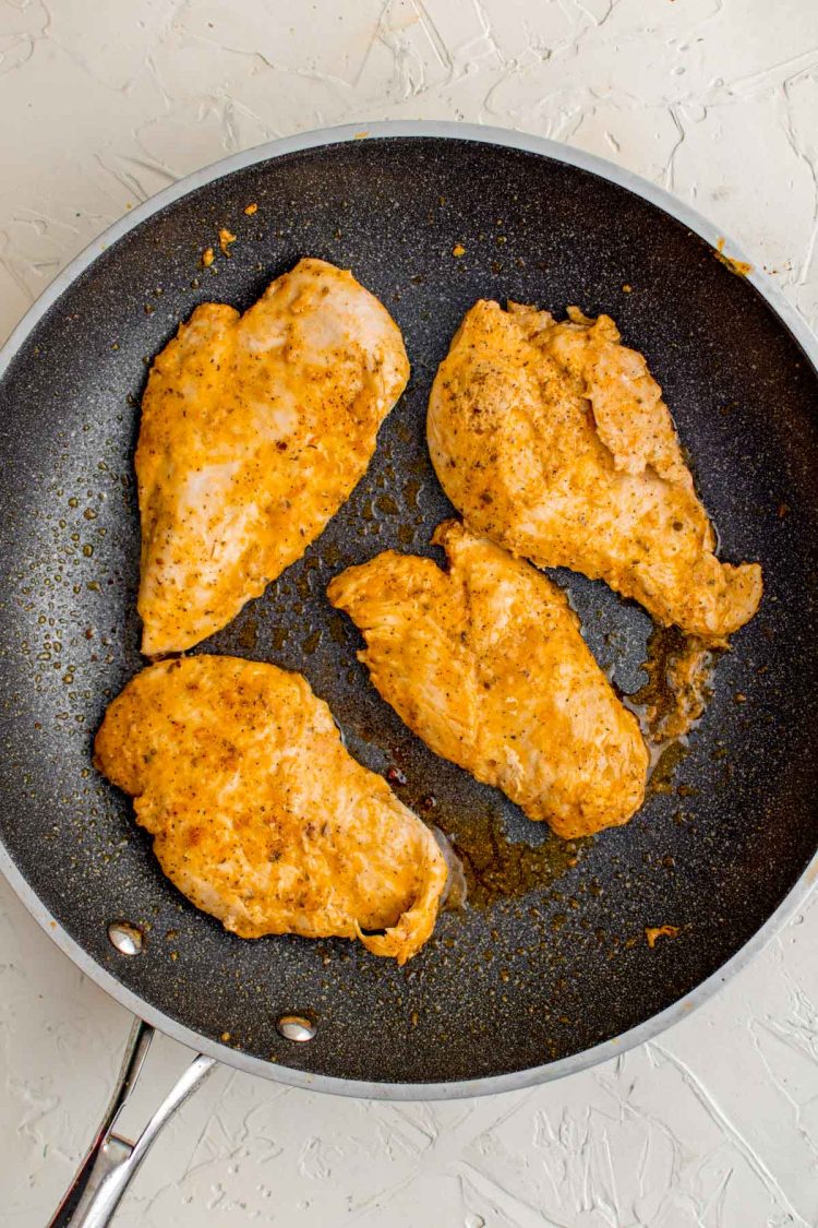 Chicken cooking in a skillet to make chicken gyros.