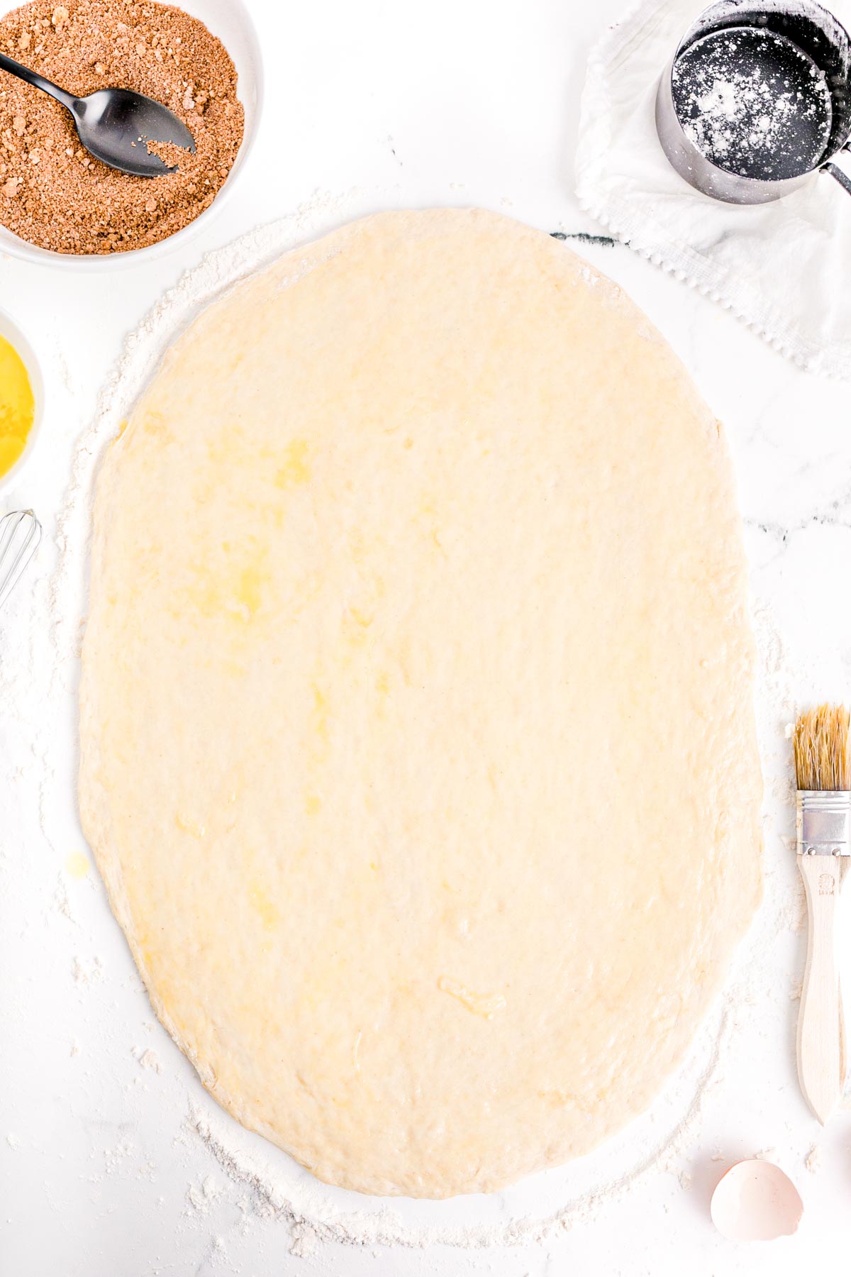 bread dough rolled out with egg wash brushed on.