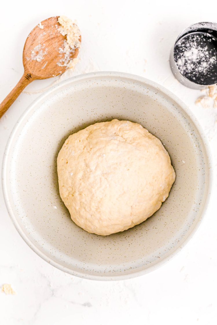 Bread dough in a ball in a bowl ready to proof.
