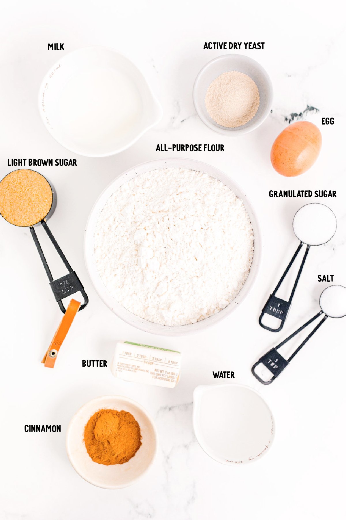 Overhead photo of ingredients to make cinnamon swirl bread prepped on a marble surface.