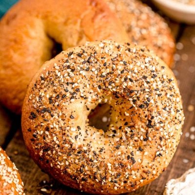 Close up photo of homemade everything bagels on a wooden table.