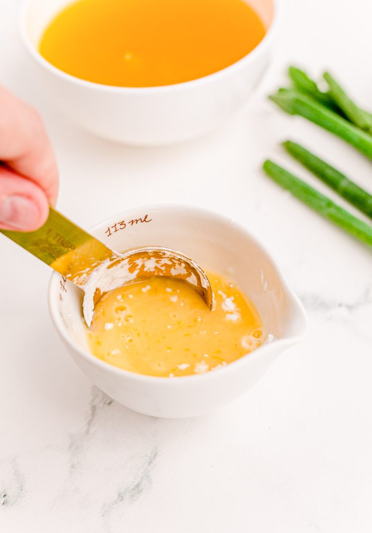 Orange juice and cornstarch mixed together in a small white bowl.