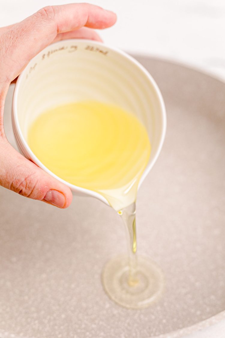 Oil being poured into a skillet.