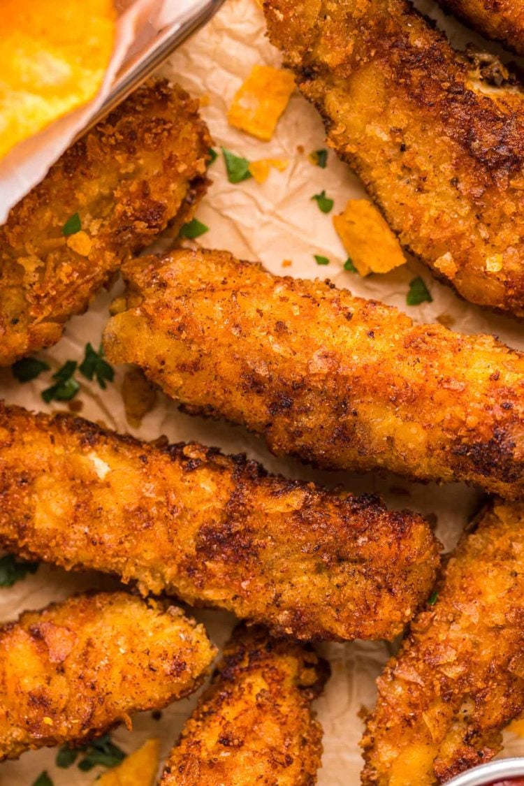 Potato chip chicken tenders on parchment paper.