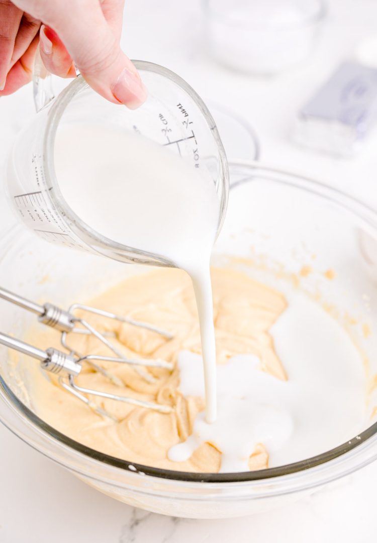 Buttermilk being poured into a glass mixing bowl.