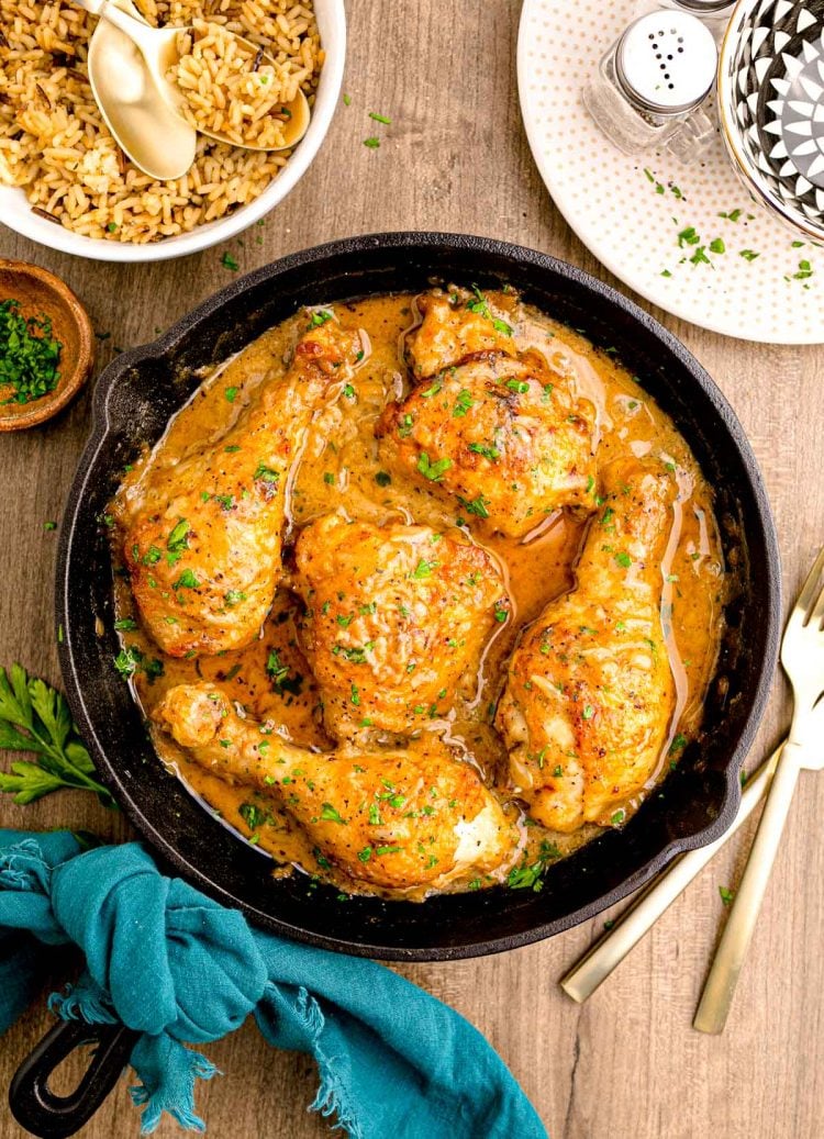 Overhead photo of a cast iron skillet with smothered chicken in it.