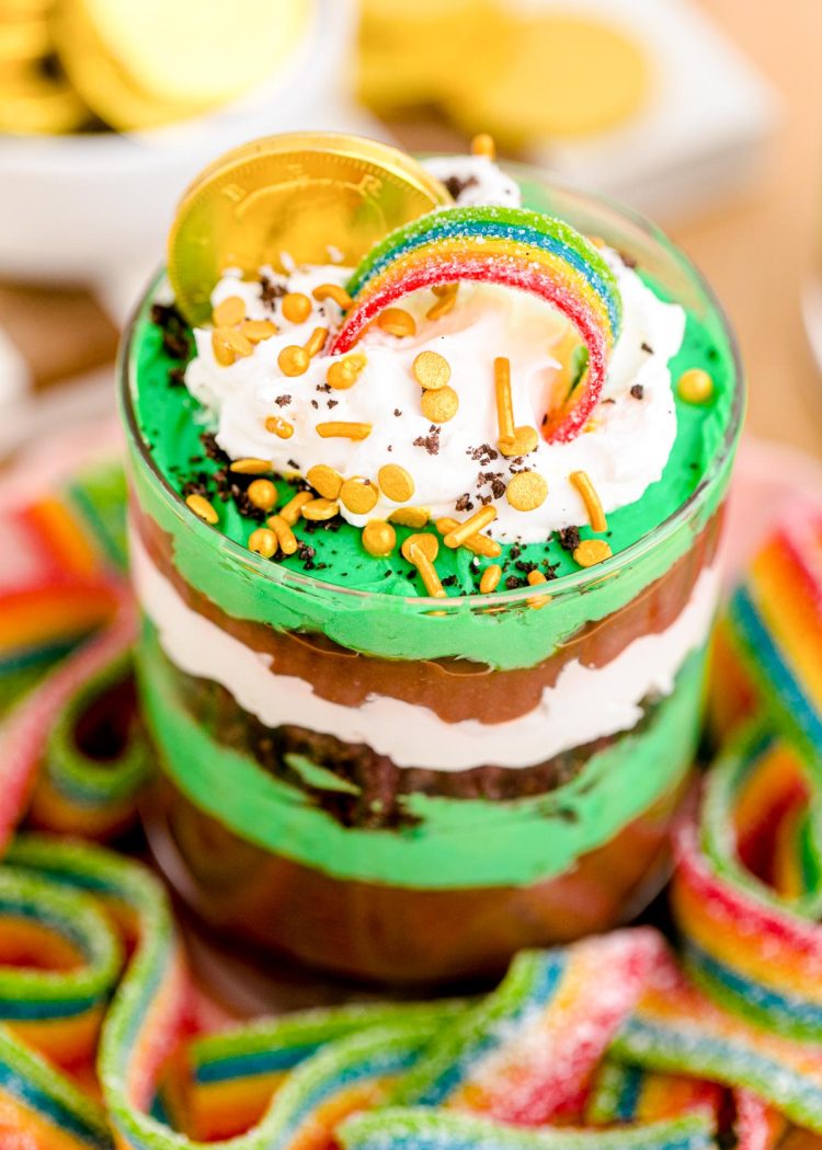 Close up photo of a St Patrick's Day Pudding and Oreo Dessert Cup on a plate with gummy rainbows.