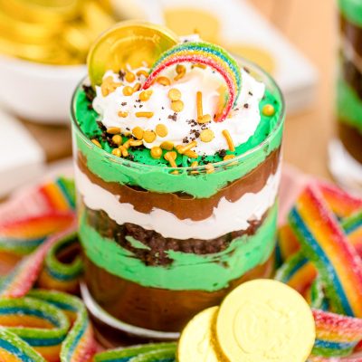 Close up photo of a St Patrick's Day Pudding and Oreo Dessert Cup on a plate with gummy rainbows.