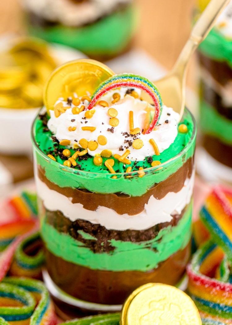 A spoon taking a bite out of a st patrick's day pudding parfait.