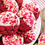 Close up photo of red velvet cookies decorated for Valentine's Day on a white plate.