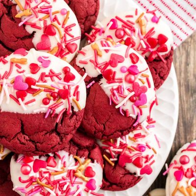 Close up photo of red velvet cookies decorated for Valentine's Day on a white plate.