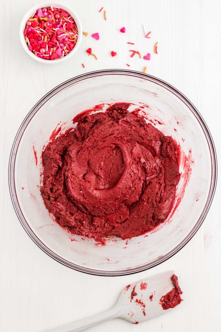 Red velvet cookie dough mixed in a glass bowl.