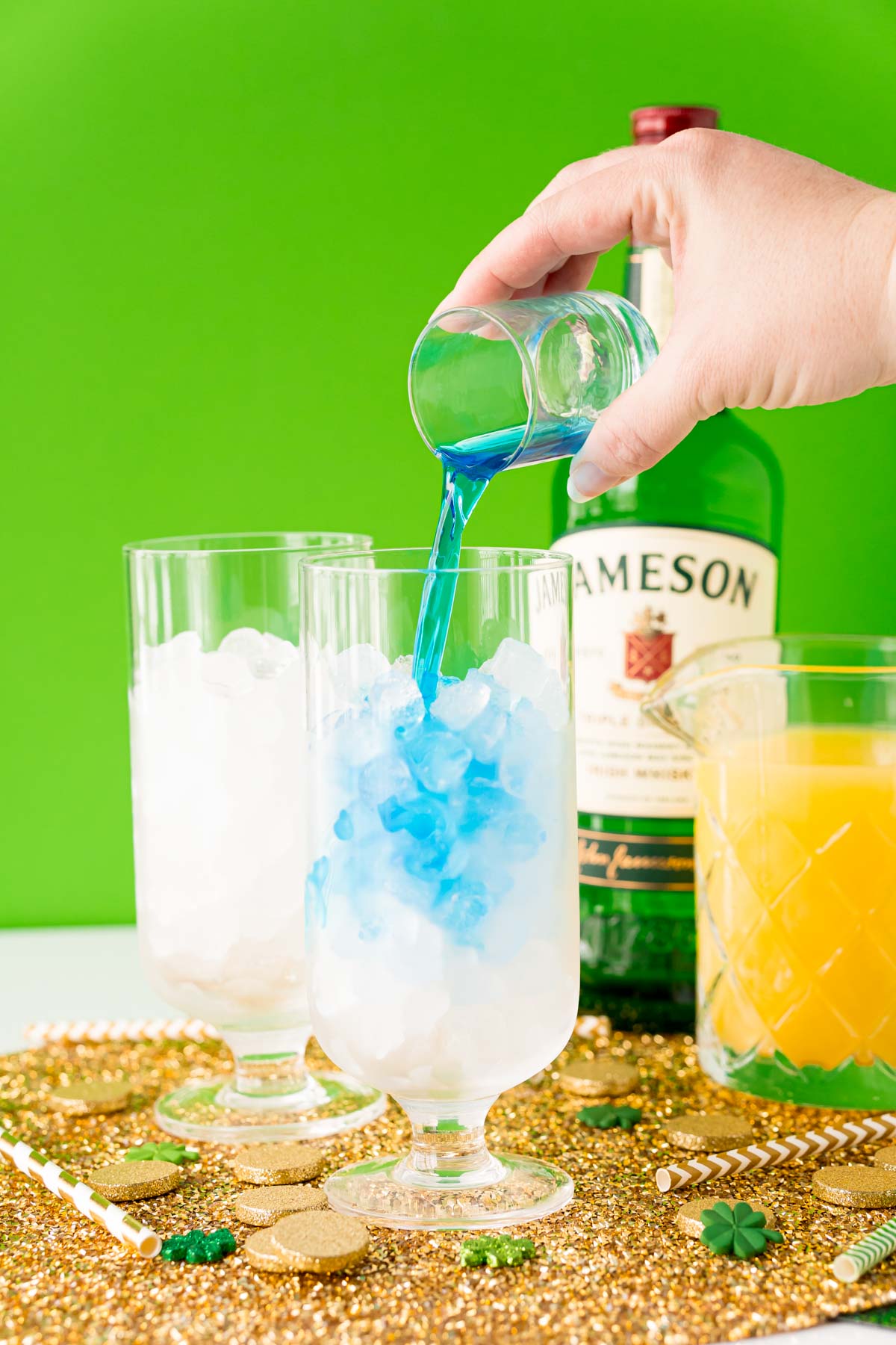 Blue curacao being poured into a glass with ice.