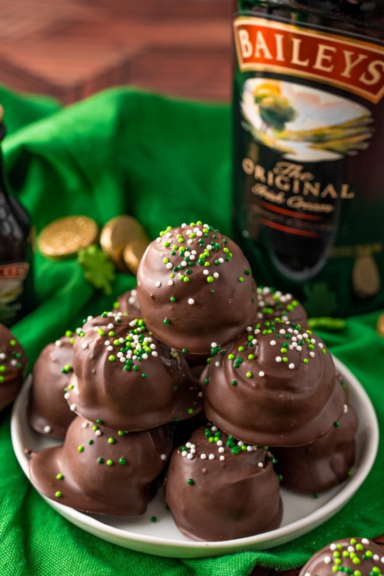 Close up photo of Bailey's Irish Cream Cheesecake Truffles on a white plate on a green napkin.