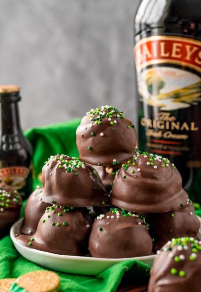 Close up photo of Bailey's Irish Cream Cheesecake Truffles on a white plate on a green napkin.