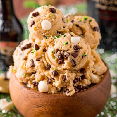 Close up photo of a wooden bowl filled with Irish Cream flavored edible cookie dough on a green placemat.