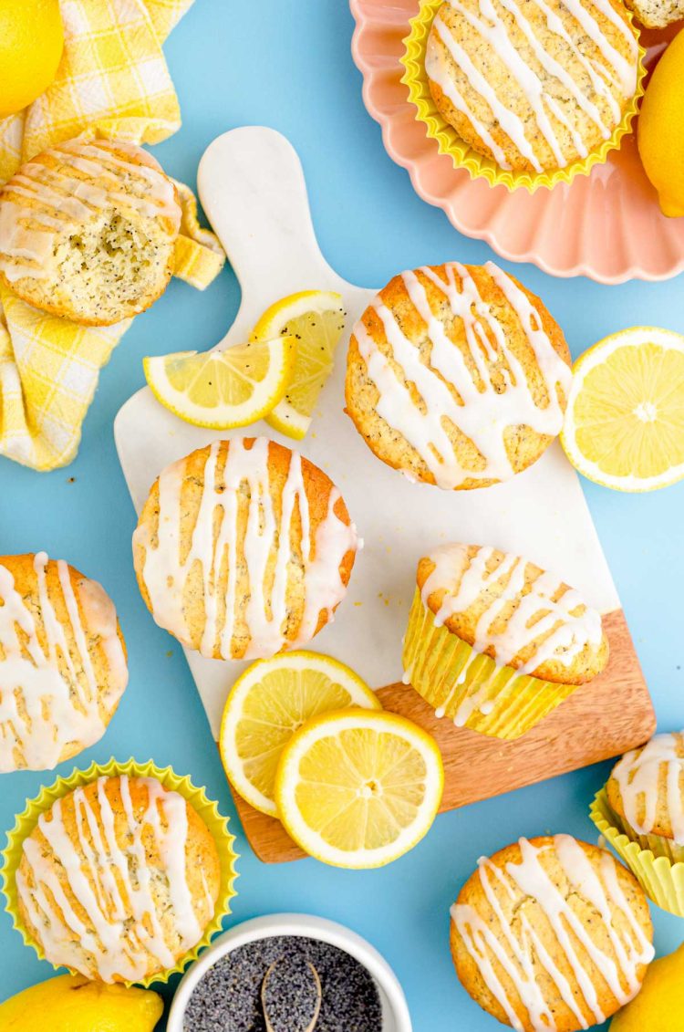 Overhead photo of lemon poppyseed muffins on a blue surface.