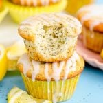 Close up photo of two lemon poppy seed muffins stacked with the top one missing a bite.