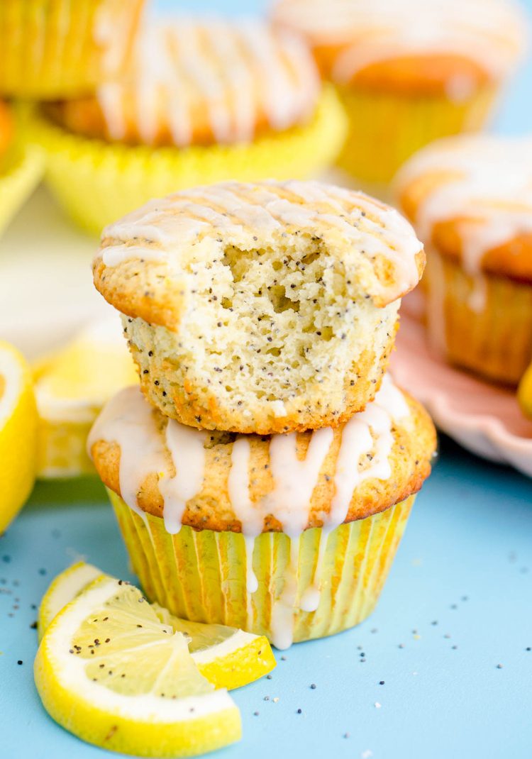 Close up photo of two lemon poppy seed muffins stacked with the top one missing a bite.