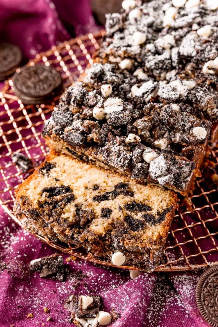 Close up photo of oreo crumb cake on a wire rack partially sliced.