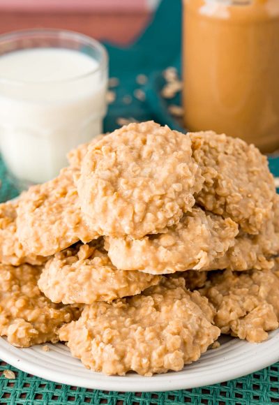 Peanut butter no bake cookies on a white plate on a teal placemat.