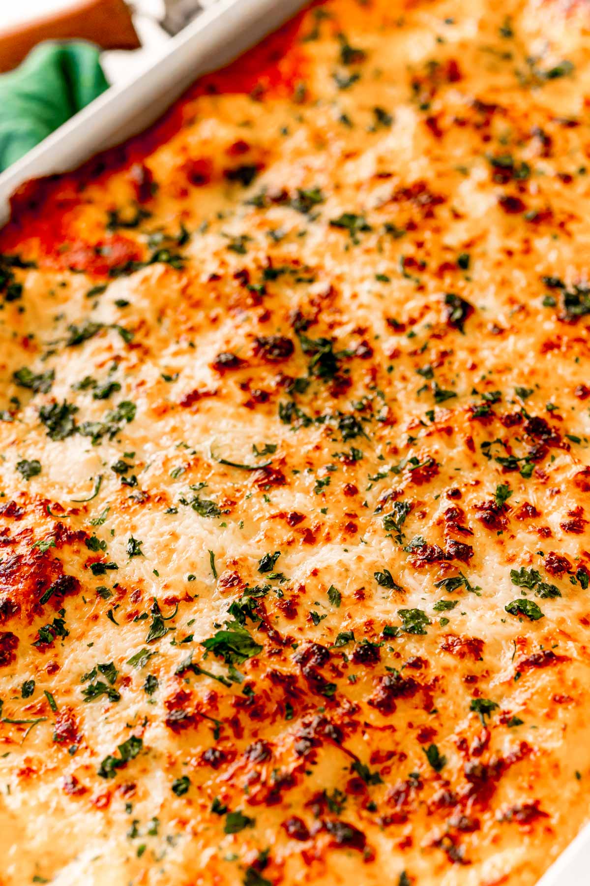 Angled photo of the top of a ravioli lasagna with bubbly cheese on top.