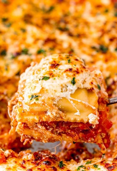 Ravioli lasagna being scooped out of a pan.