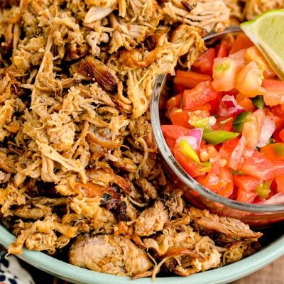 Pork carnitas in a teal bowl with pico de gallo.